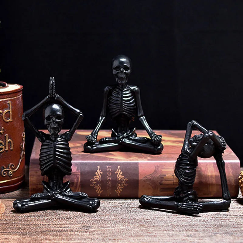 Detailed resin Halloween ornament of a yoga-posing skeleton skull on a desktop.