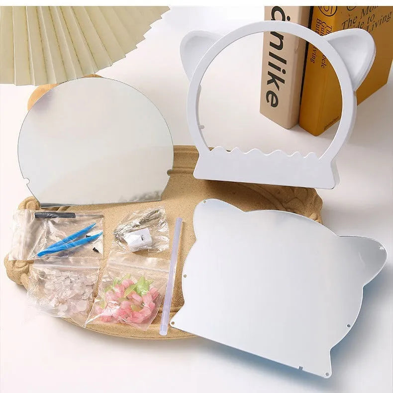 DIY craft kit for a cat head night lamp surrounded by handmade pink, blue, and purple tulip flowers.