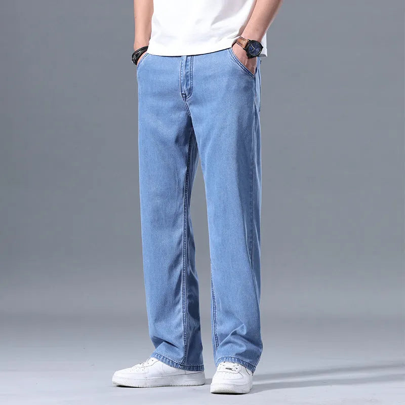 Men's light blue loose straight-leg lyocell jeans with zip fly on a neutral background.