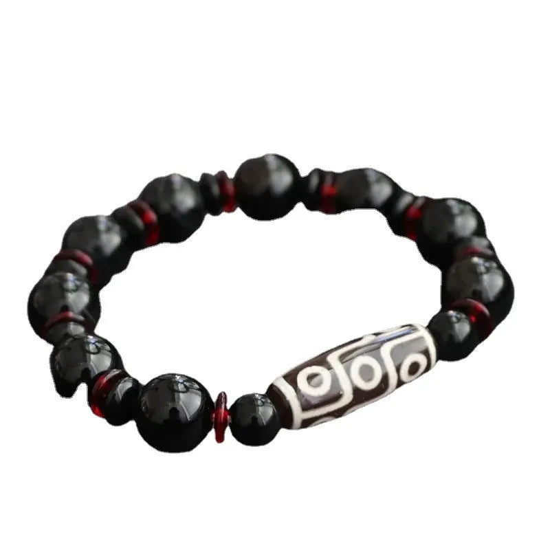 Hand-woven black agate dzi bead bracelet with 11mm geometric beads on a wrist.
