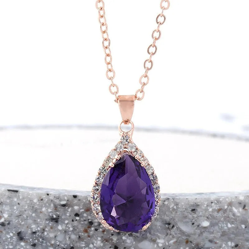 Water drop shaped pendant necklace with geometric design and rhinestone accents in pink colour