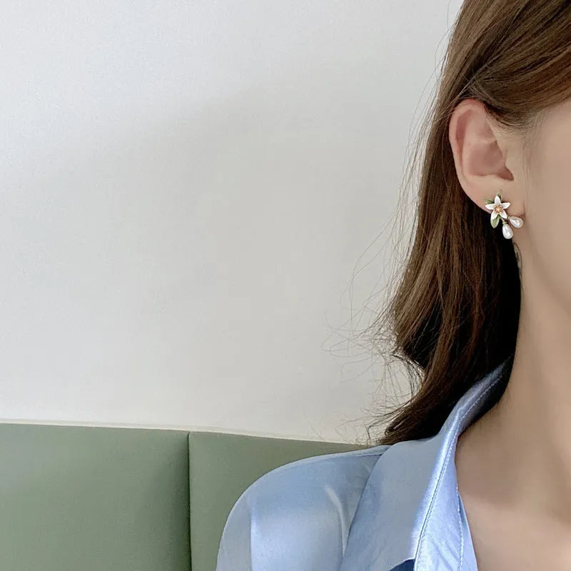 A pair of women's alloy flower earrings shown in two style options: sterling silver needle flowers and a coloured flower clip.