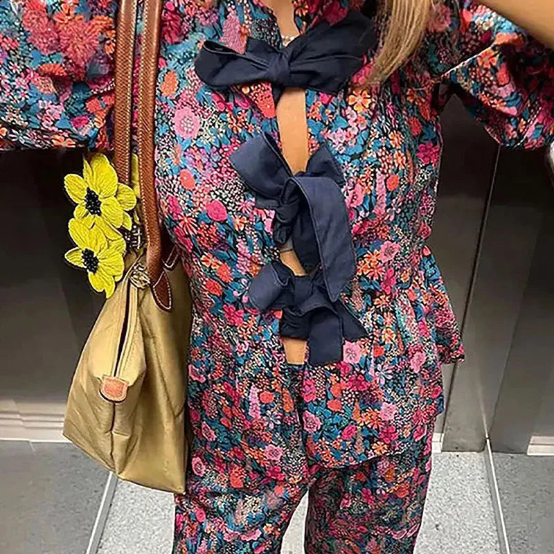 Floral print trousers suit with tie-neck top and puff sleeves, matching two-piece set