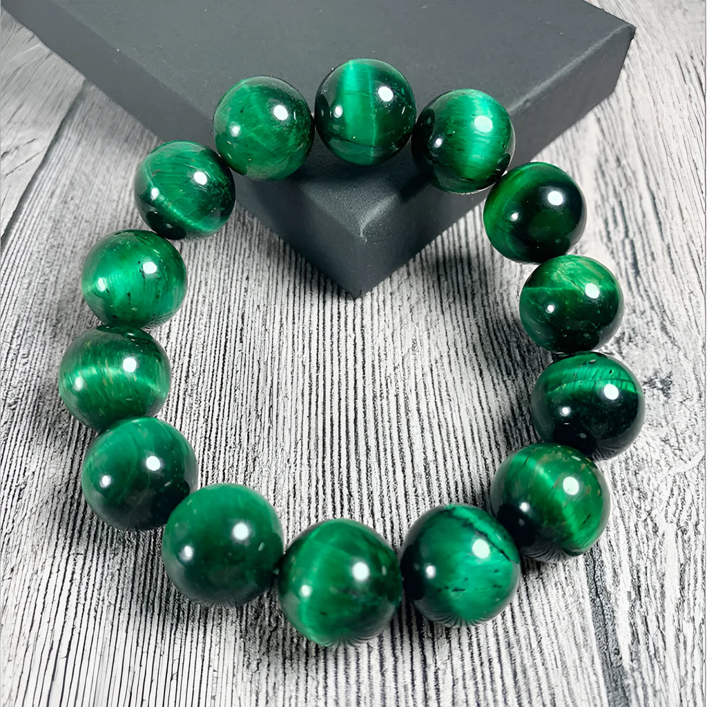 Green tiger eye stone bracelet with polished geometry beads on a wrist, showing the stone's natural banding.
