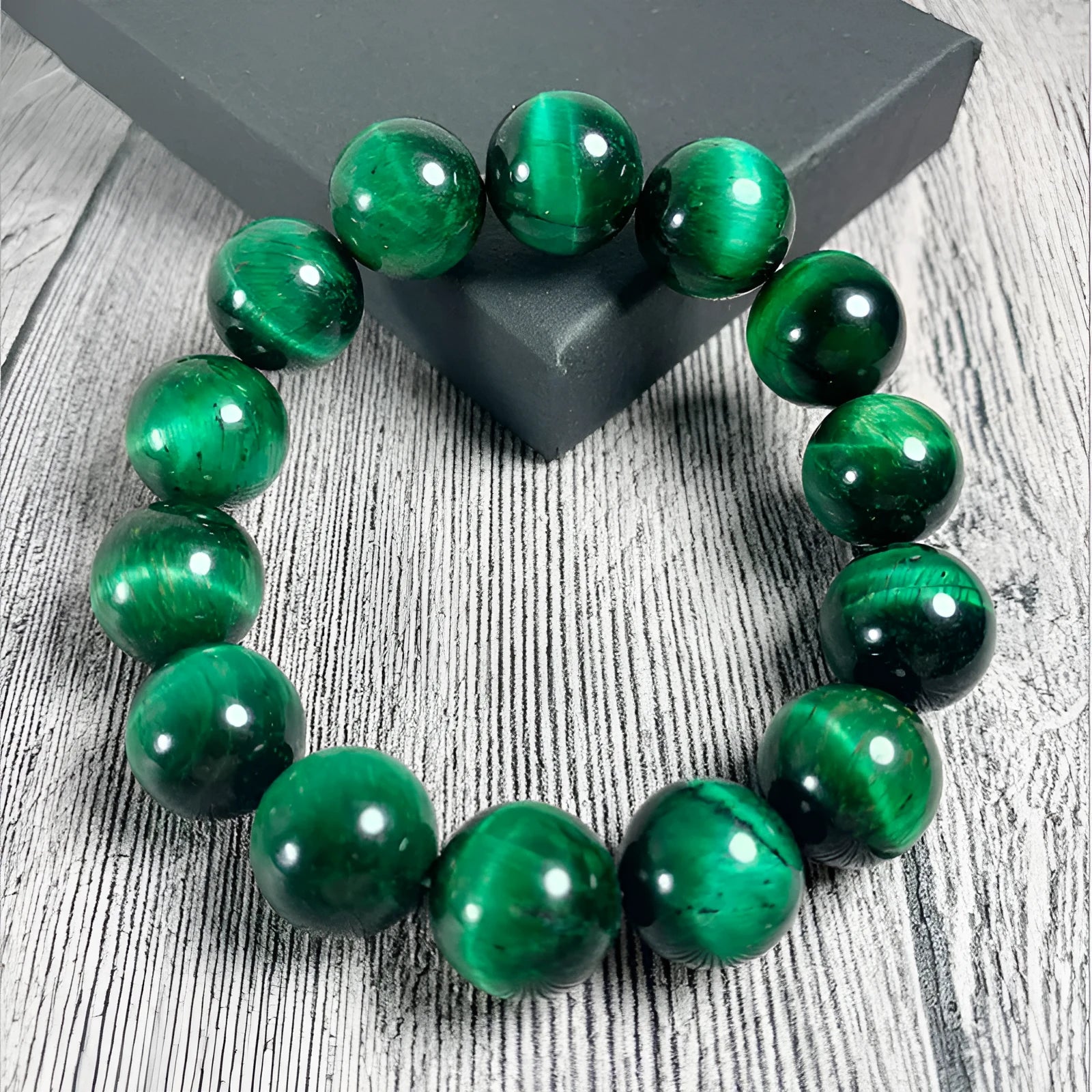 Green tiger eye stone bracelet with polished geometry beads on a wrist, showing the stone's natural banding.
