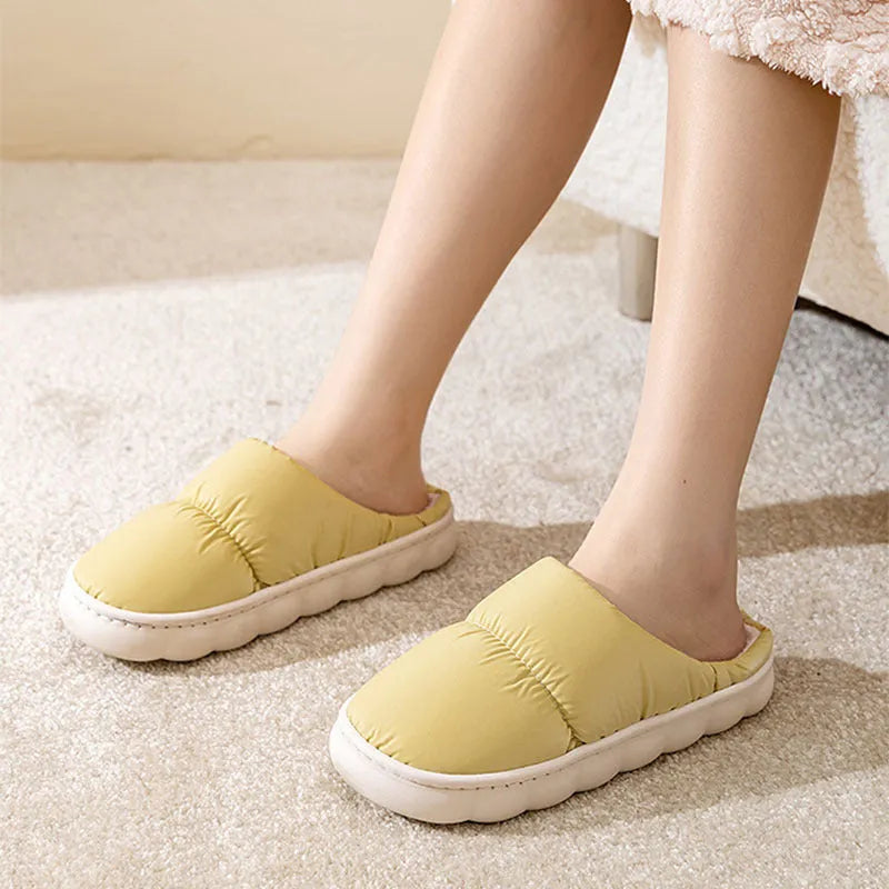 Blue winter indoor slippers with thick rubber sole and plush lining, shown on a hard floor.