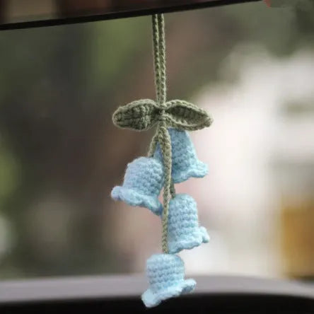 Green and white knitted wool car plant decoration basket with white hanging cord.