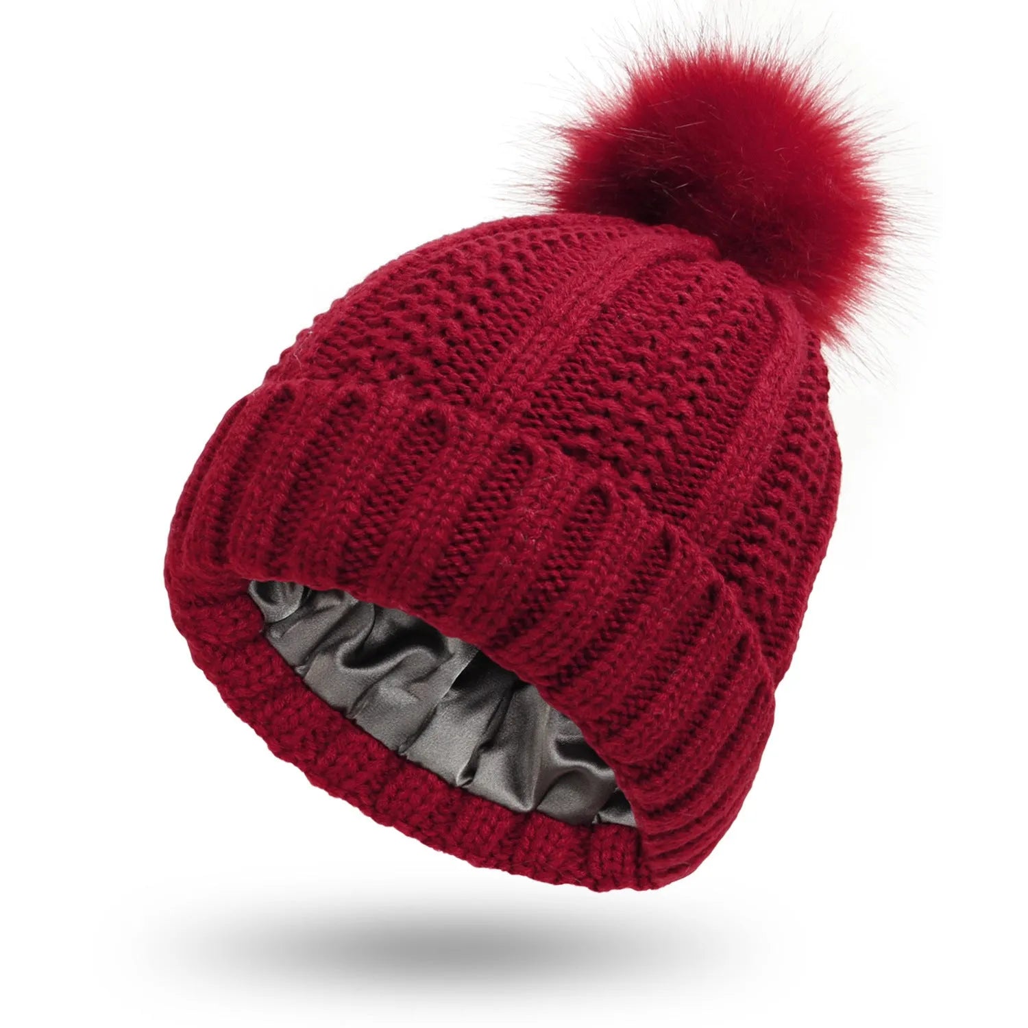 Women's knitted beanie hat with faux fur pom pom, shown with satin lining exposed, available in multiple colours.