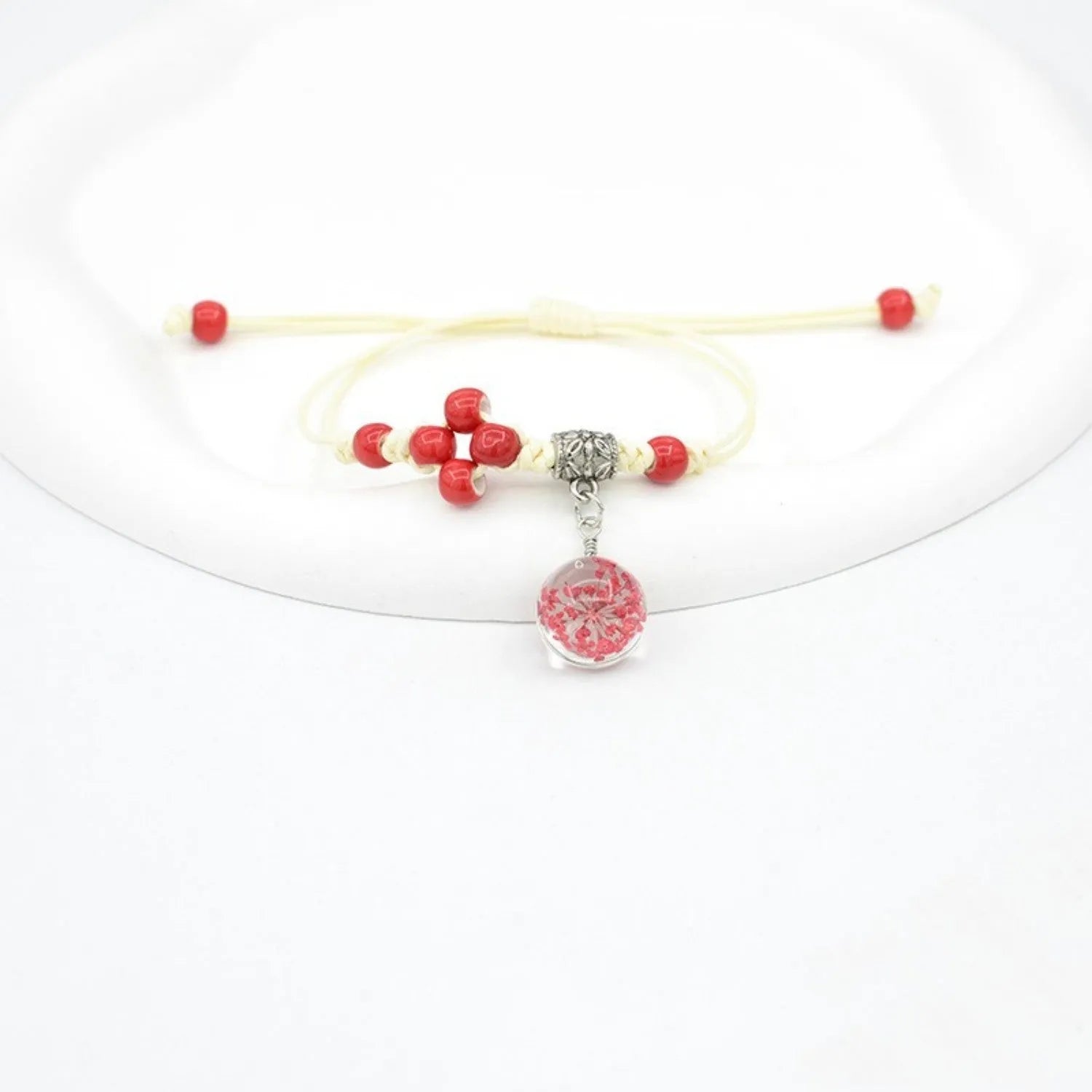 Women's hand-woven glass bracelet with large 1.4cm beads containing dried flowers, shown in blue colour option