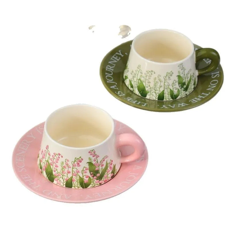 Ceramic coffee cup set with two matching cups, saucers, and stirring spoons featuring hand-painted couple designs