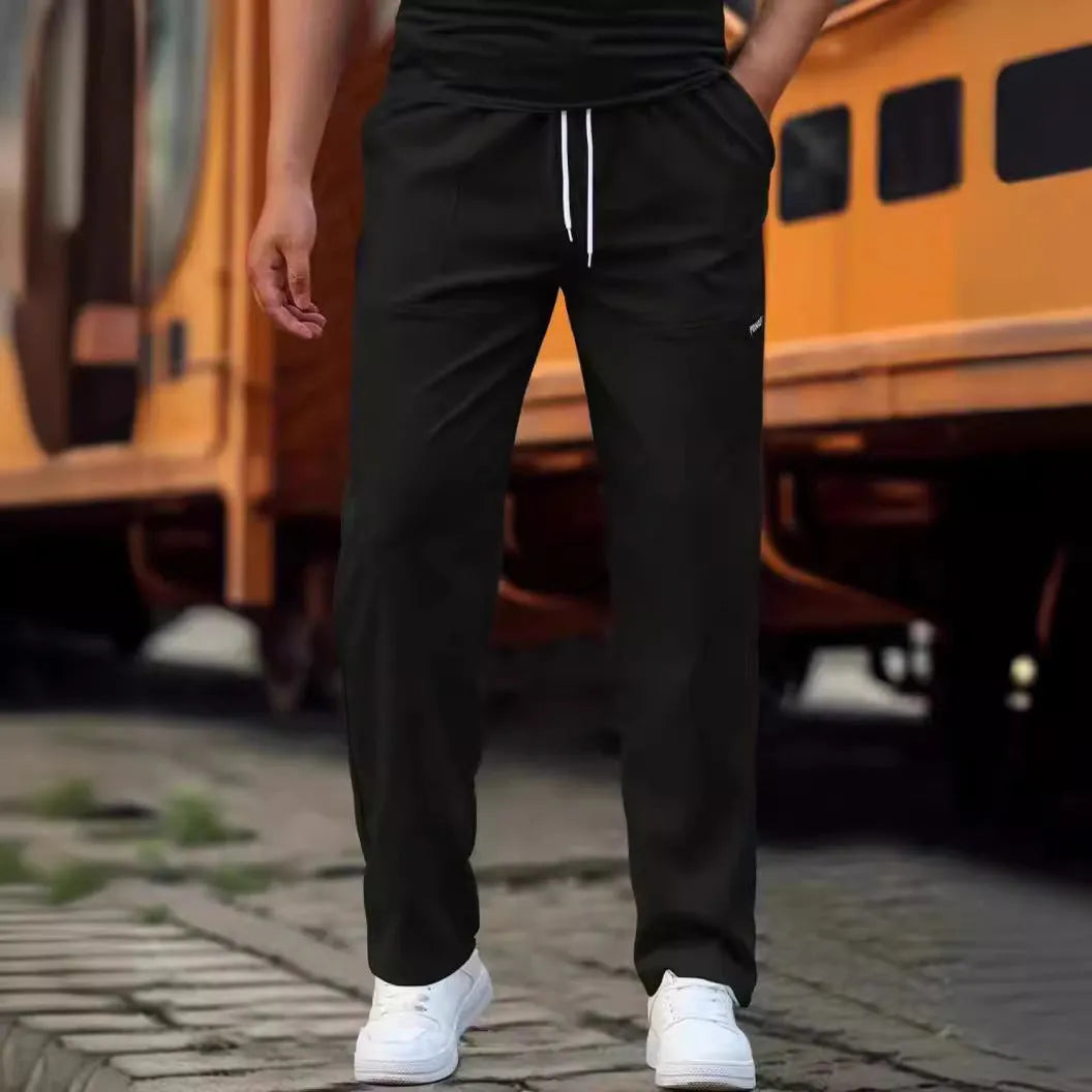 Men's polyester trousers in light grey colour, shown folded, for spring and autumn wear.