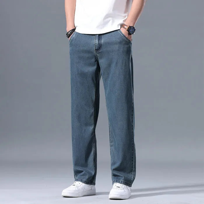 Men's light blue loose straight-leg lyocell jeans with zip fly on a neutral background.