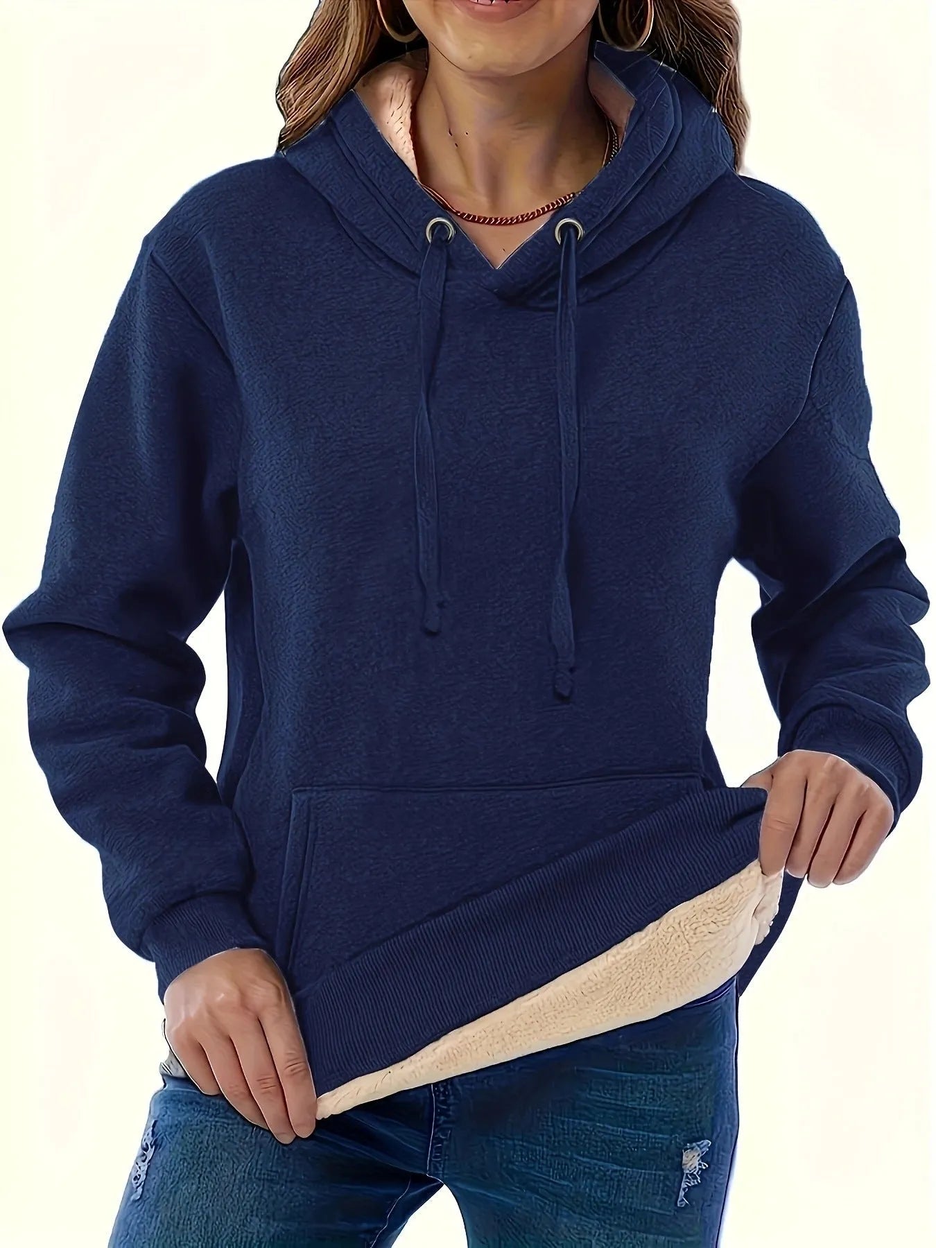 Woman wearing a loose black hooded sweater with a raised 3D pattern on the fabric.