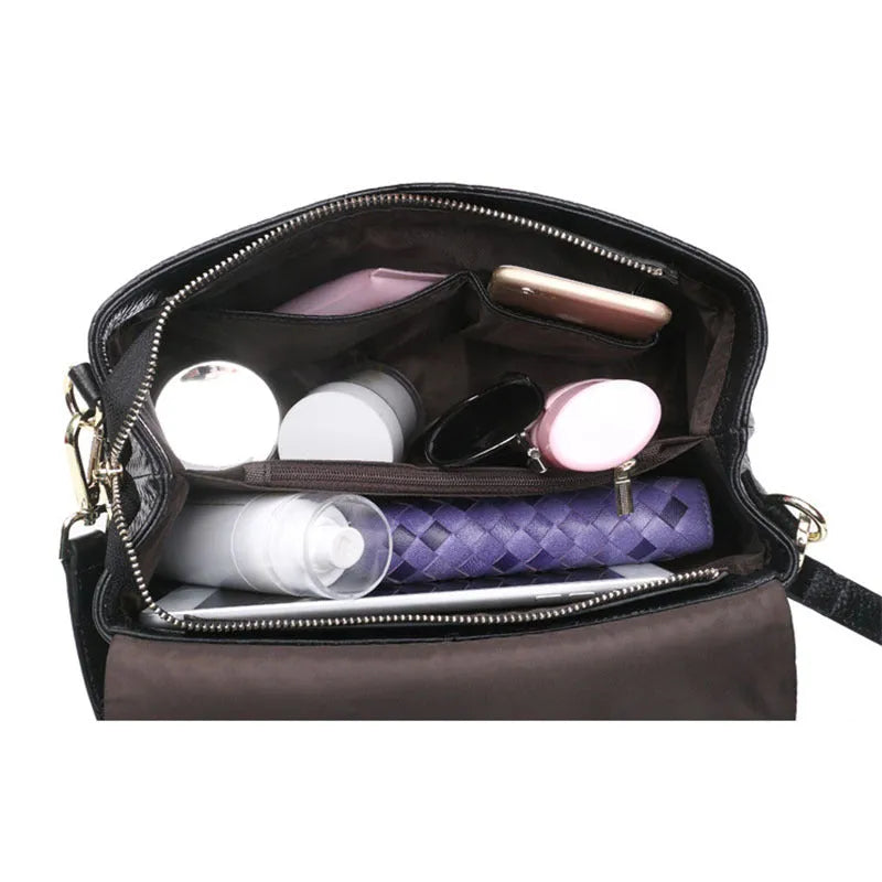Black genuine leather woven crossbody bag with embossed finish, soft carry handle, and single shoulder strap.