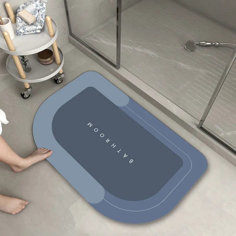 Blue oval blended fabric bathroom floor mat placed on tiled floor.