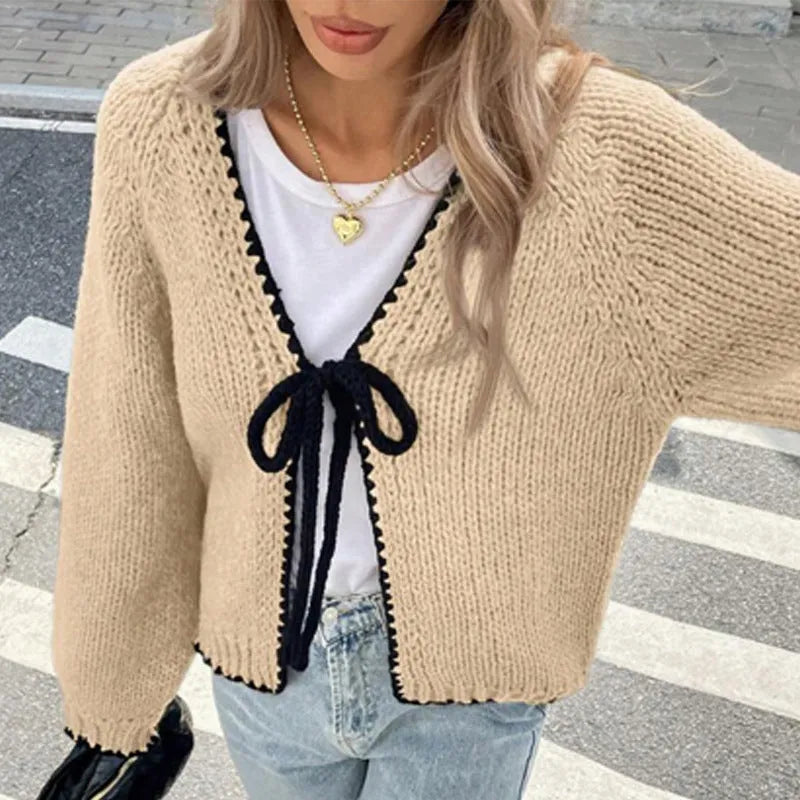 Grey lace-up front cardigan with crocheted flower detail on sleeve, shown loose and open.