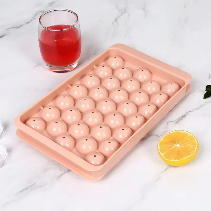 Blue round silicone ice cube tray with 33 grids and a clear lid, shown next to pink version