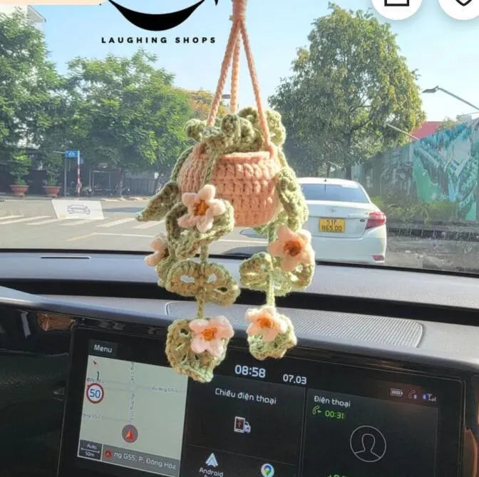 Green and white knitted wool car plant decoration basket with white hanging cord.