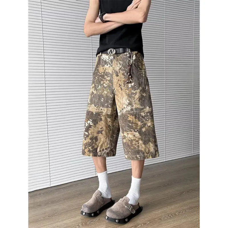 Men's yellow denim jeans with a snake pattern and camouflage tooling print, showing cropped leg length.