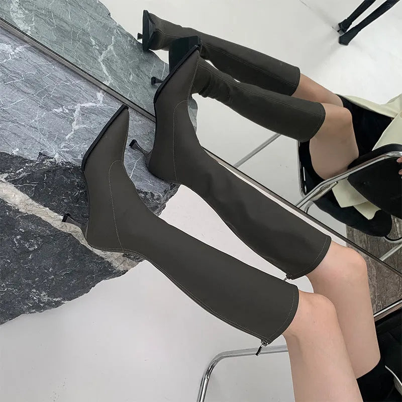 Black women's below knee pointed toe stiletto heel boots with a back zipper