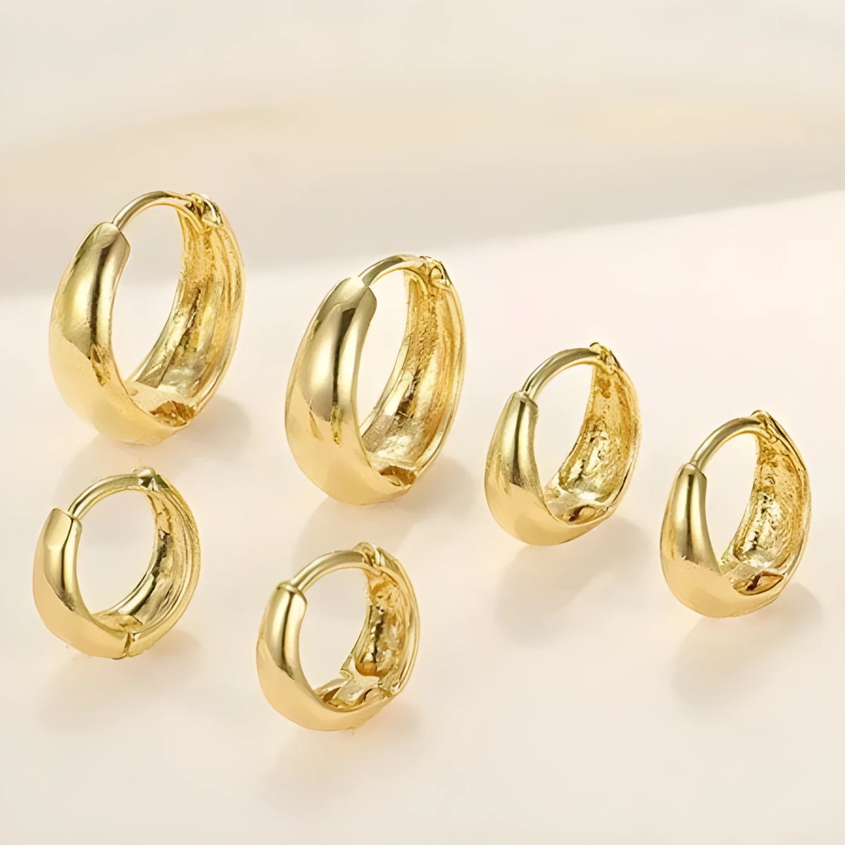 Gold electroplated copper geometric ring earrings for women, shown as a single pair or three-pair set.