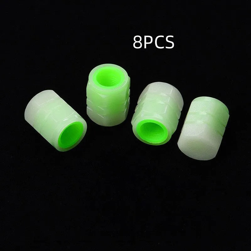 Pack of four black rubber car valve caps with luminous glow-in-the-dark tops.