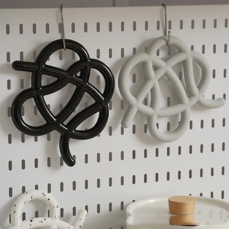 Ceramic heat proof mat in an irregular shape on a kitchen countertop.