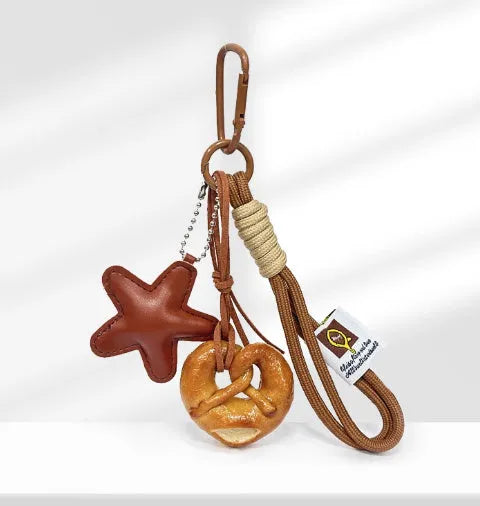 Handmade soda bread style handbag pendant with brown strap showing cartoon baked goods design