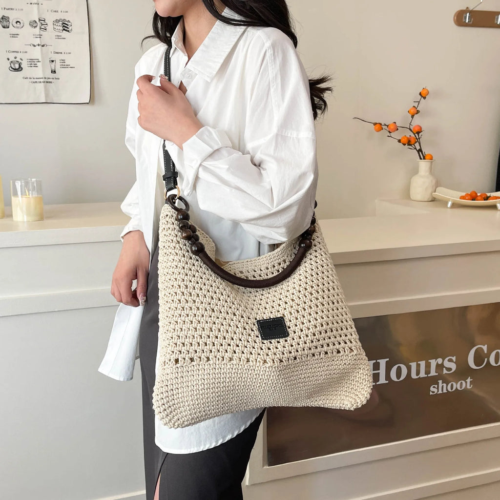 Knitted beach tote bag with crossbody strap showing stitching details and bucket shape