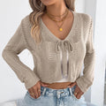 Women's khaki long-sleeved coat with hollow-out pattern, worn open as a casual cardigan.