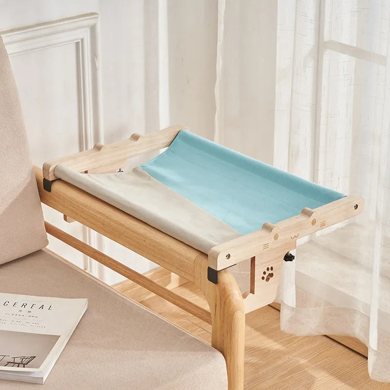 Wooden cat hanging bed with fabric hammock installed on balcony railing