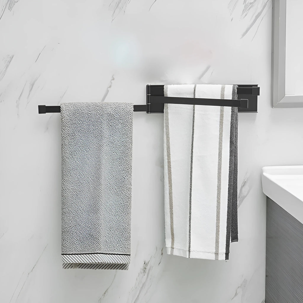 Black folding towel bar mounted on a bathroom wall with adhesive, shown in extended and folded positions.