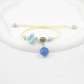 Women's hand-woven glass bracelet with large 1.4cm beads containing dried flowers, shown in blue colour option