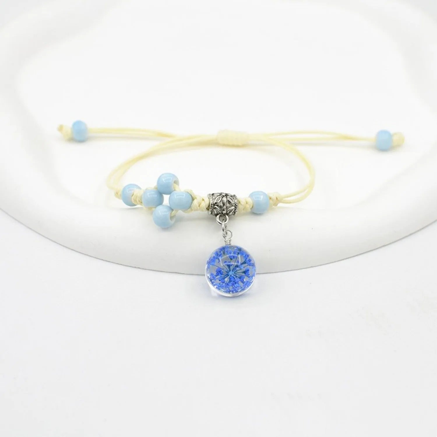 Women's hand-woven glass bracelet with large 1.4cm beads containing dried flowers, shown in blue colour option