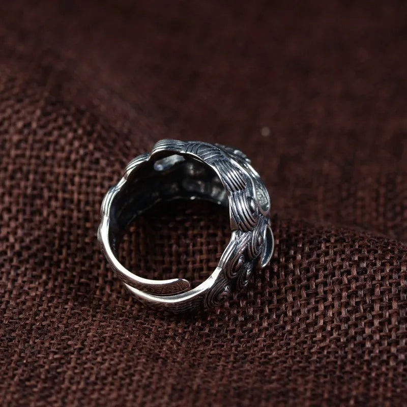 Silver open ring with a detailed domineering Jibeast animal pattern on a model's finger.