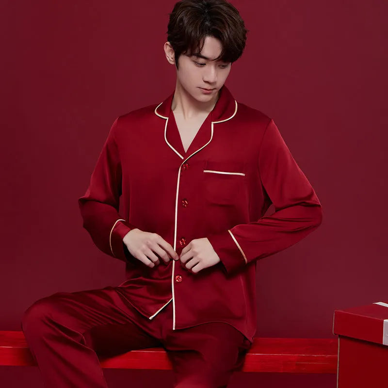 Red matching men's and women's silk sleepwear set with long sleeves and trousers.