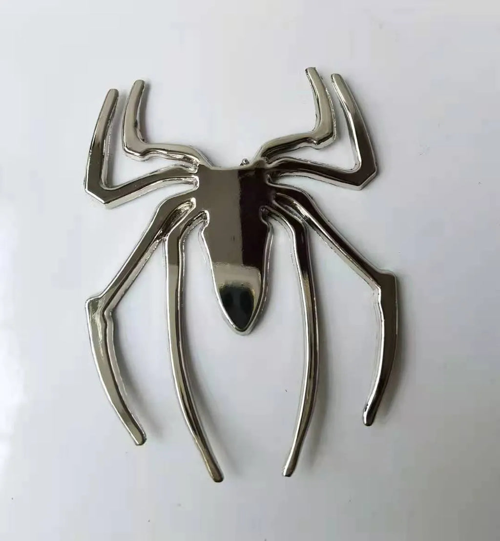 Three-dimensional metal spider bumper sticker in gold finish, measuring 7cm by 5cm.