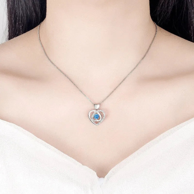Blue diamond electroplated heart necklace and bracelet set with gem inlay on a geometric pendant.