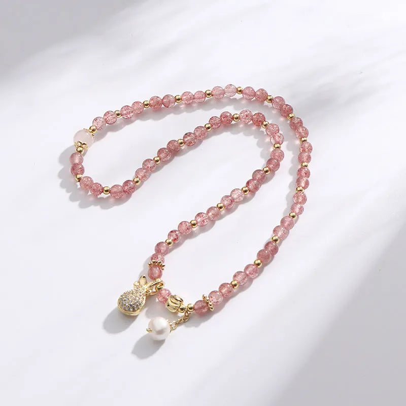 Close-up of a women's geometric bracelet made from pink strawberry quartz crystals.