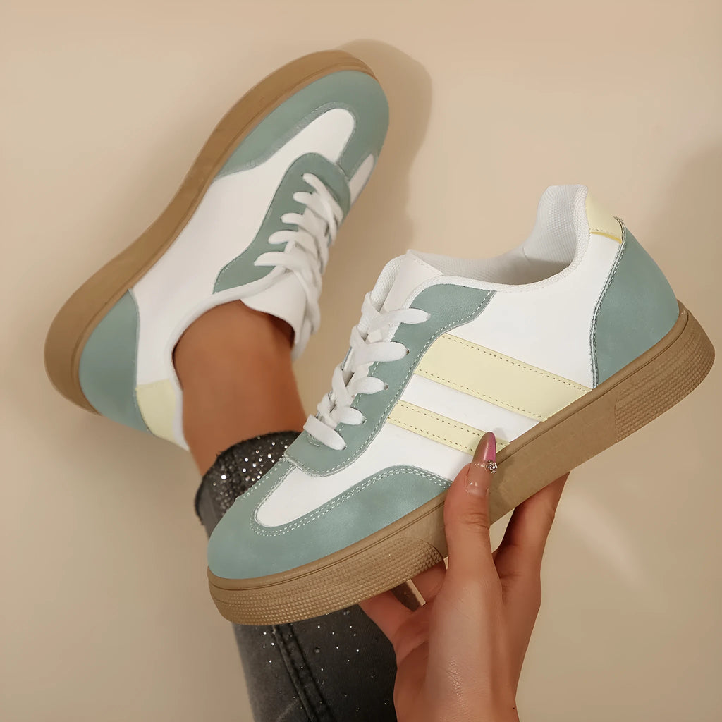 Green women's retro sports pumps with cross straps and leather stitching details