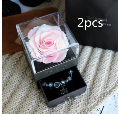 Glass eternal flower jewellery box with preserved roses and carnations inside measuring 8.5cm square