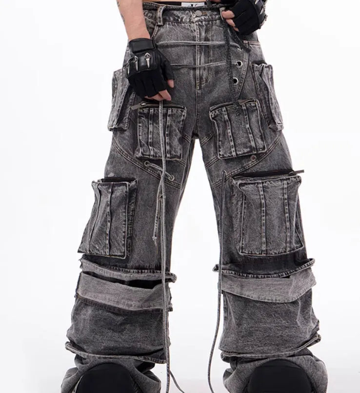 Grey distressed denim overalls with rope stitching on the legs, shown in a casual fit.