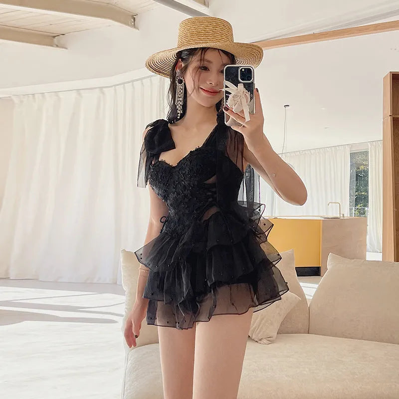 Black one-piece swimsuit with gathered chest detail and sleeveless conservative cut for women