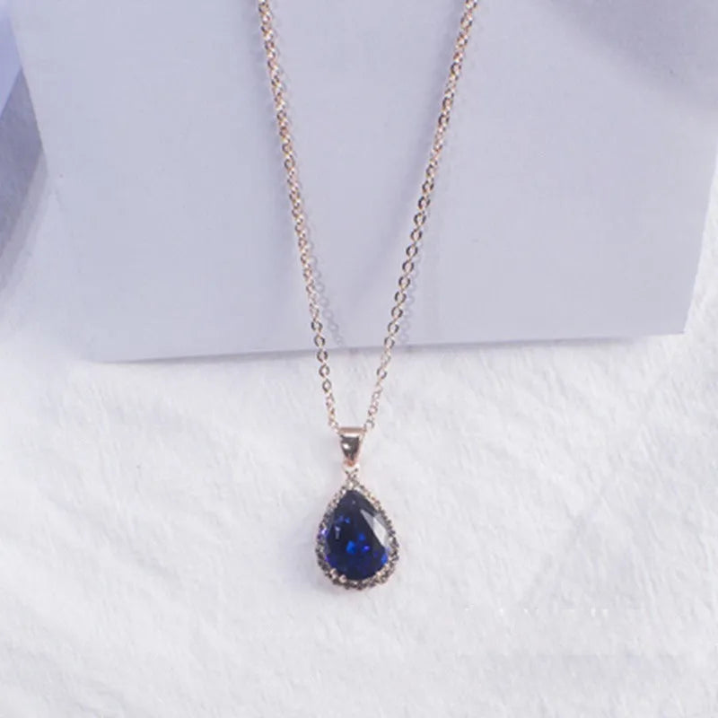 Water drop shaped pendant necklace with geometric design and rhinestone accents in pink colour