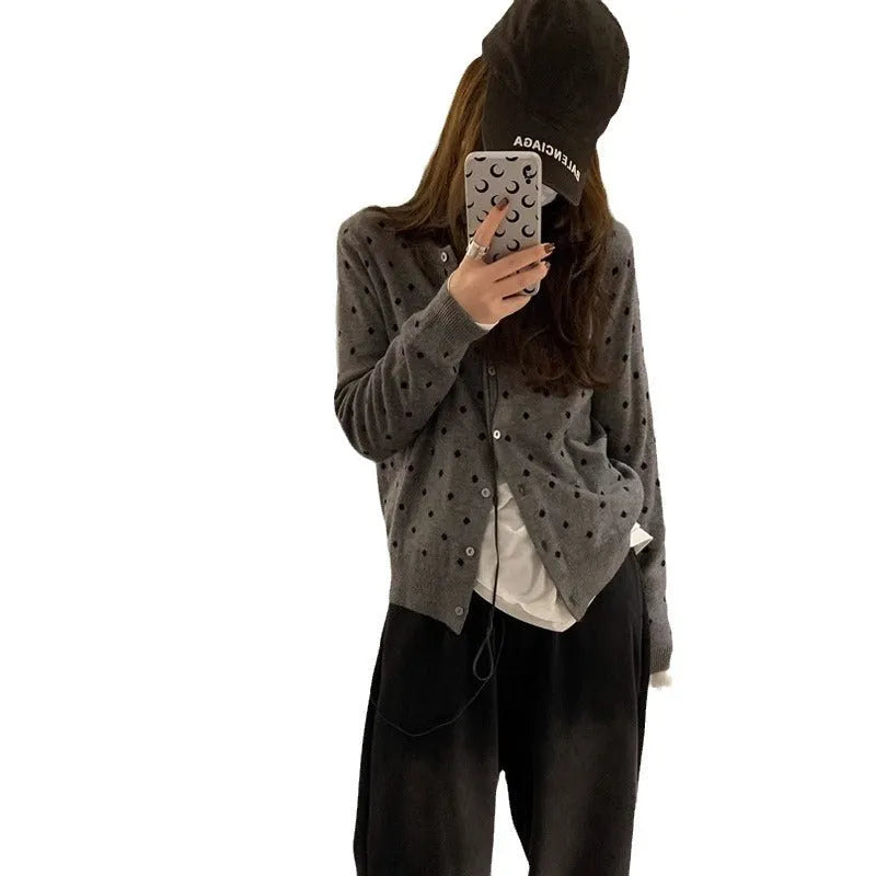 Women's loose fit grey dot knitted cardigan with crocheted flower trim on long sleeves.