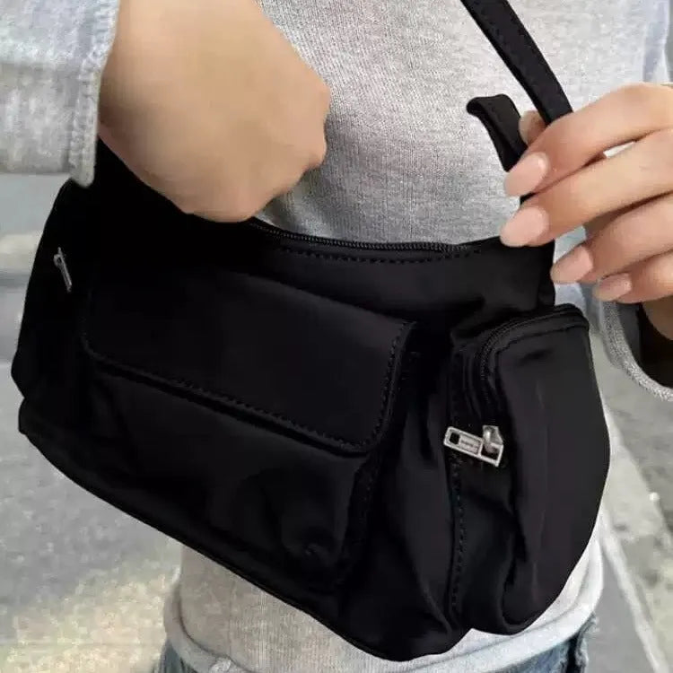 Black nylon shoulder bag with double pockets and side line detail, showing compact dimensions