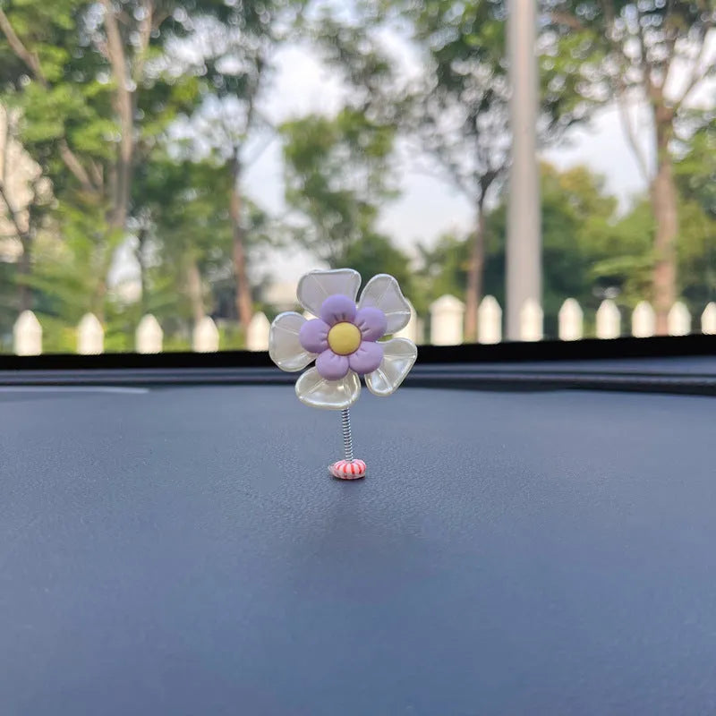 Small colourful plastic swing car decoration in blue, green, pink, purple, and yellow options.