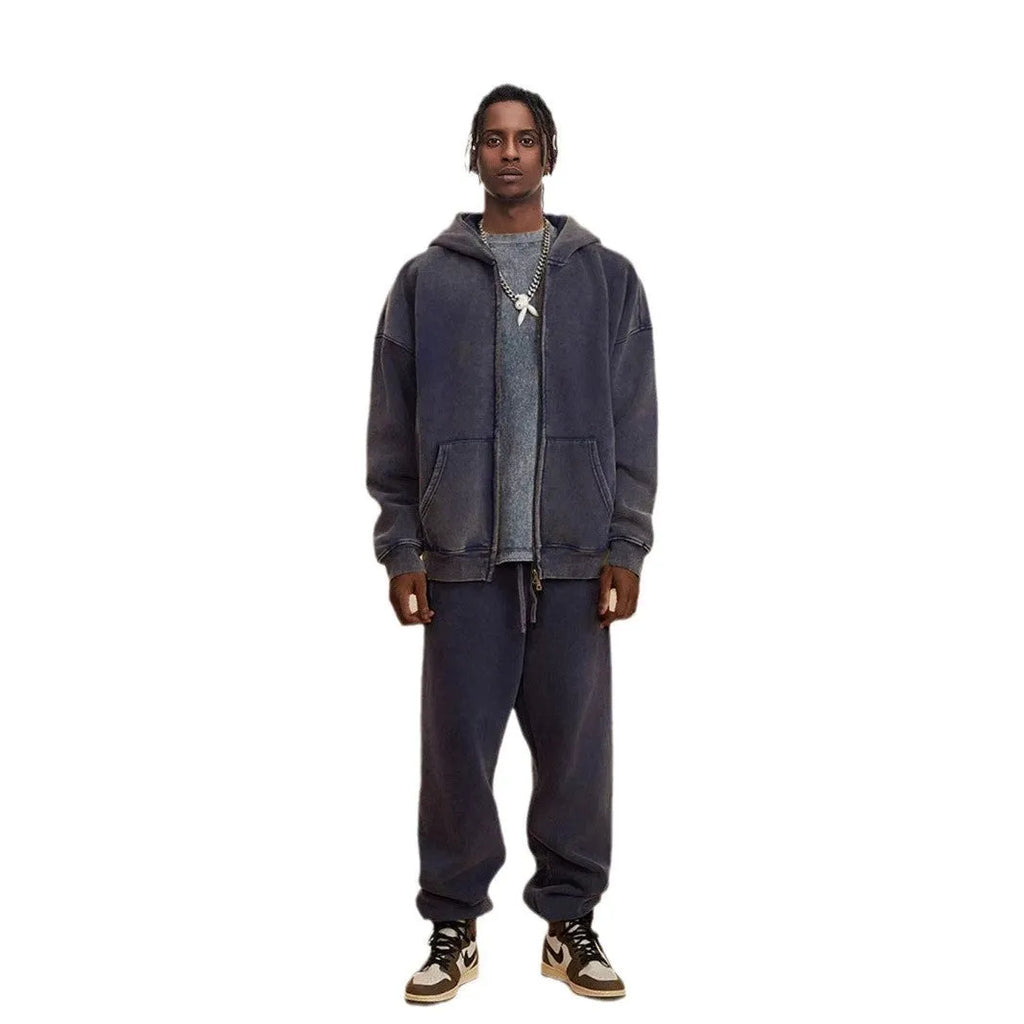 Man wearing a washed black fleece-lined hooded cardigan with a double zipper front.