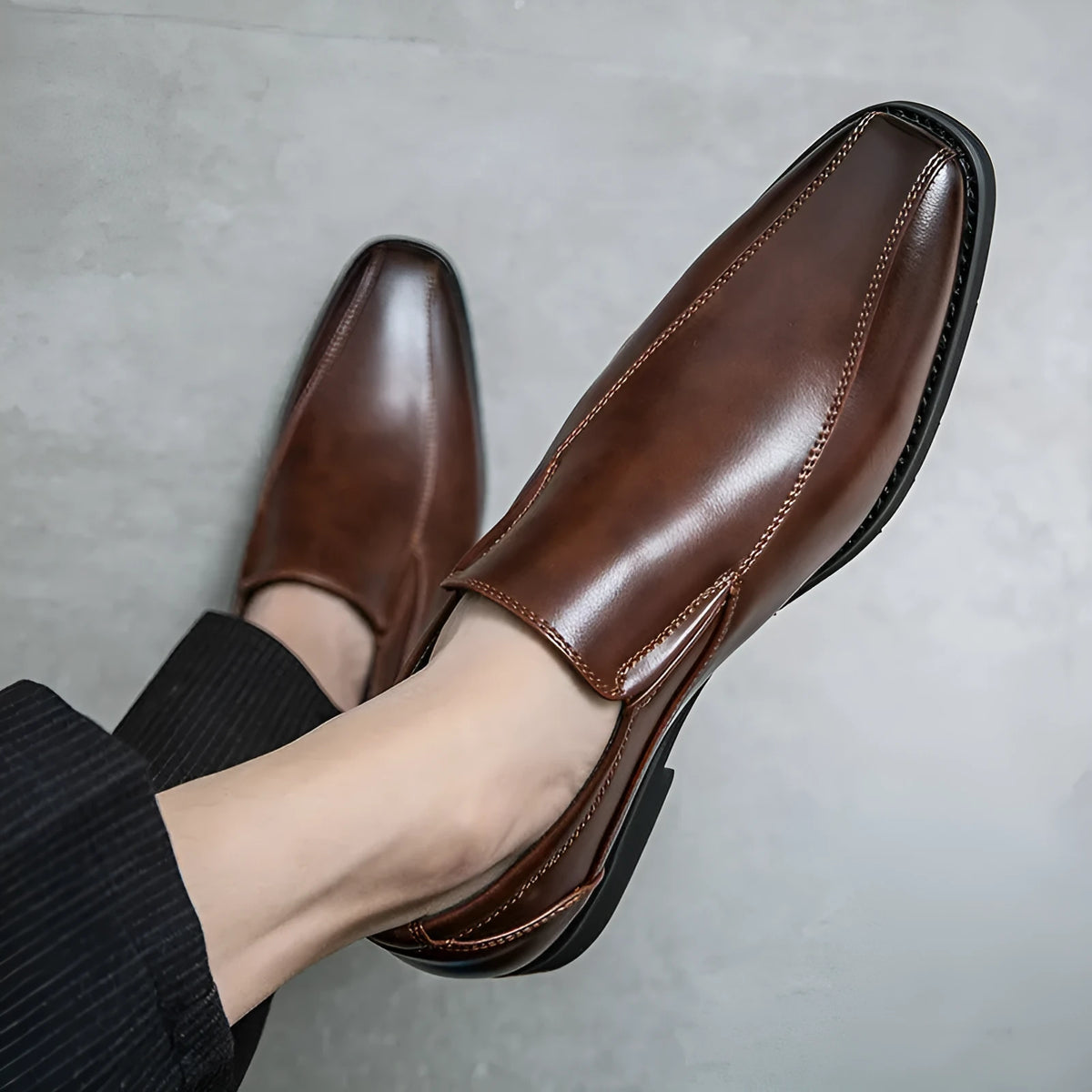Men's black pointed patent leather casual shoes with flat rubber sole and low tube sock.