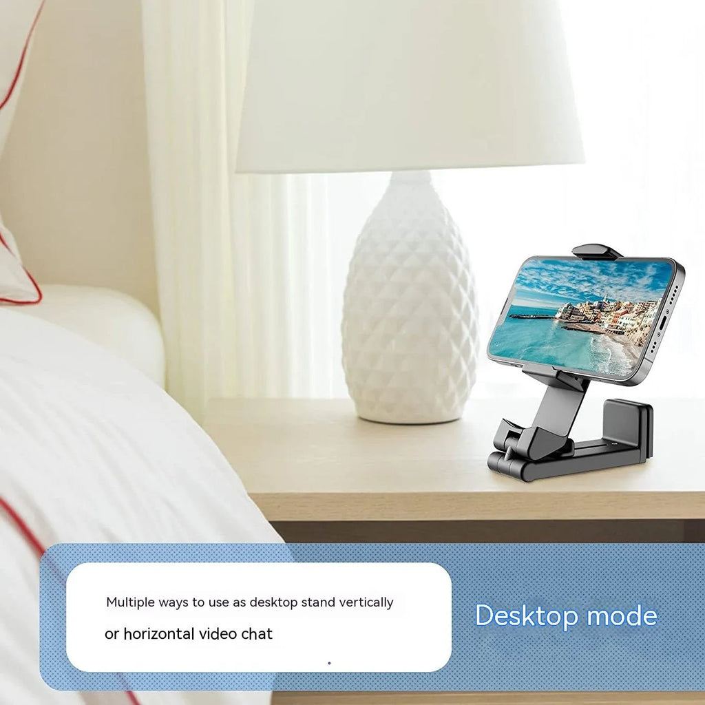 Black foldable rotating phone stand holding a mobile phone in landscape orientation on a desk.